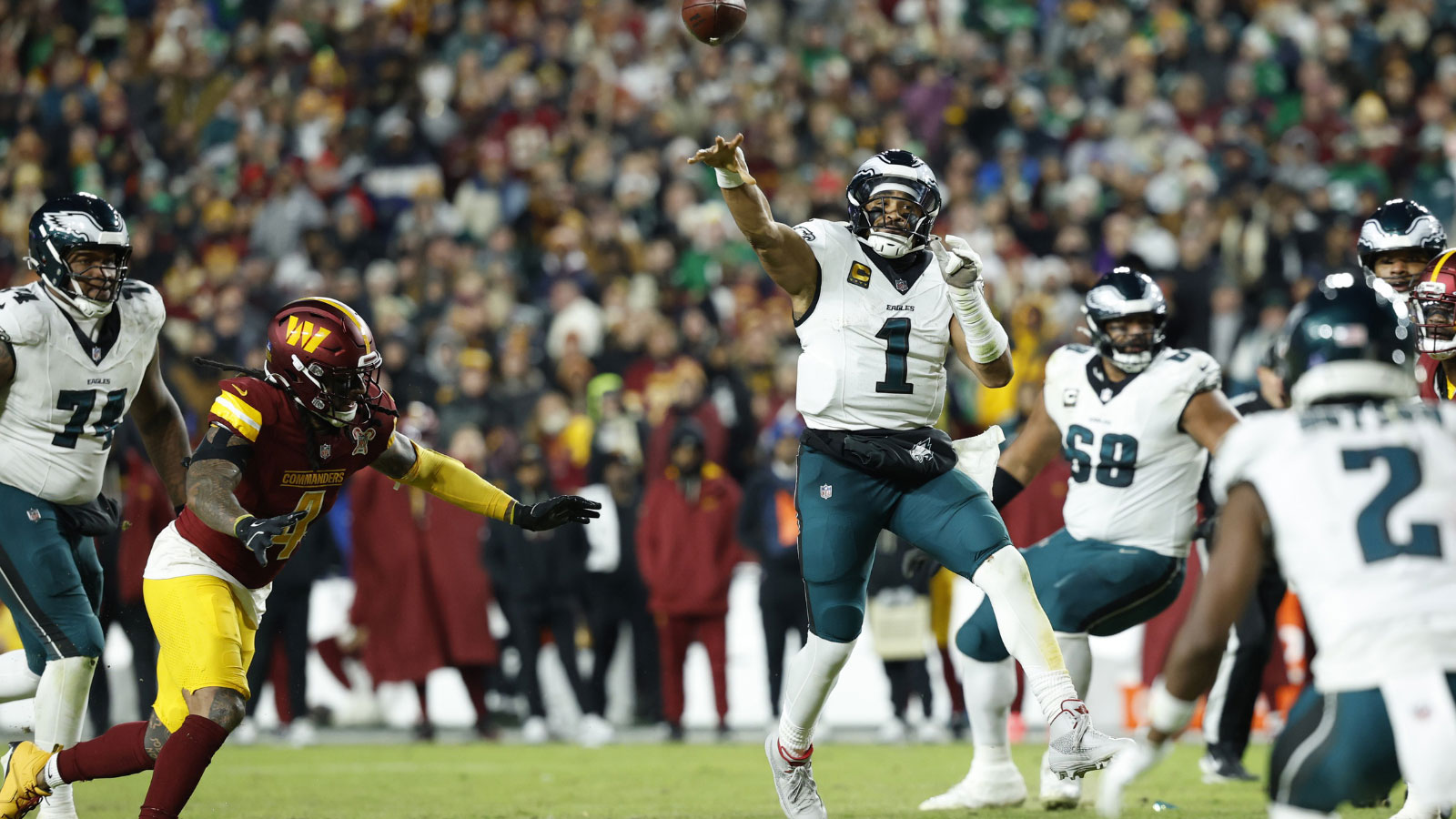 Philadelphia Eagles quarterback Jalen Hurts (1) passes against Washington Commanders linebacker Frankie Luvu (4) in the second half at Northwest Stadium.