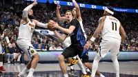 Dallas Mavericks forward Cooper Flagg (32) looks to pass the ball by Denver Nuggets center Jonas Valanciunas (17) and guard Bruce Brown (11) during the game between the Mavericks and the Nuggets at the American Airlines Center