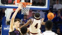 Caption: Saint Francis forward Ralph Martino Jr. (4) shoots under pressure from Florida center Olivier Rioux (32) during the second half of an NCAA mens basketball game at Steven C. O'Connell Center Exactek arena in Gainesville, FL