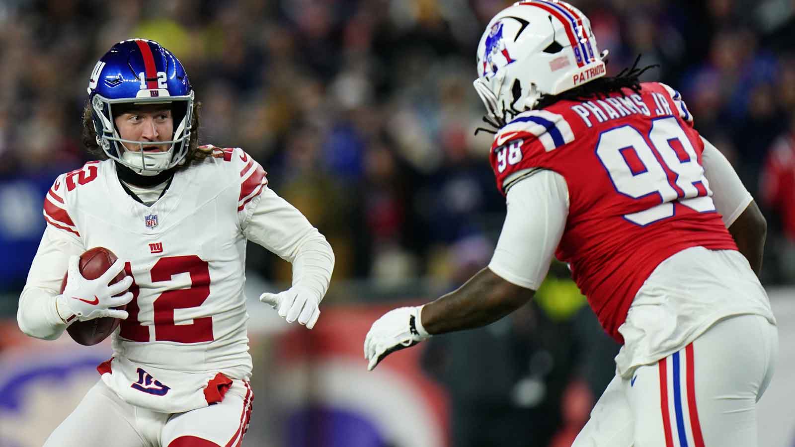 New York Giants punter Jamie Gillan (12) runs with the ball against New England Patriots defensive tackle Jeremiah Pharms Jr. (98) during the second quarter at Gillette Stadium. 