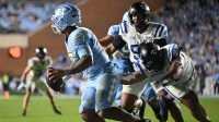 North Carolina Tar Heels quarterback Gio Lopez (7) scrambles away from Duke Blue Devils defensive tackle Josiah Green (4) during the second half at Kenan Stadium.