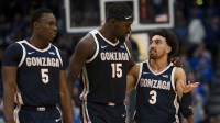 Gonzaga Bulldogs forward Emmanuel Innocenti (5), forward Graham Ike (15), and guard Braeden Smith (3) walk back to the bench against the Kentucky Wildcats during the first half at Bridgestone Arena.