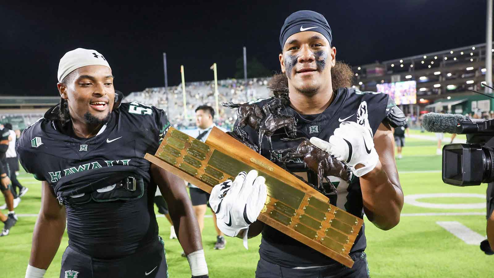 Hawaii Rainbow Warriors hoist the Paniolo Award Trophy after the game against the Wyoming Cowboys at Clarence T.C. Ching Athletics Complex. 