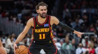 Hawks guard Trae Young (11) points to teammates during the game against the Miami Heat during the third quarter at State Farm Arena with the Knicks logo and the Hawks' injury report in the background