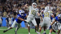 Georgia Tech Yellow Jackets quarterback Haynes King (10) throws the ball as BYU Cougars linebacker Nusi Taumoepeau (5) pressures during the second half at Camping World Stadium.