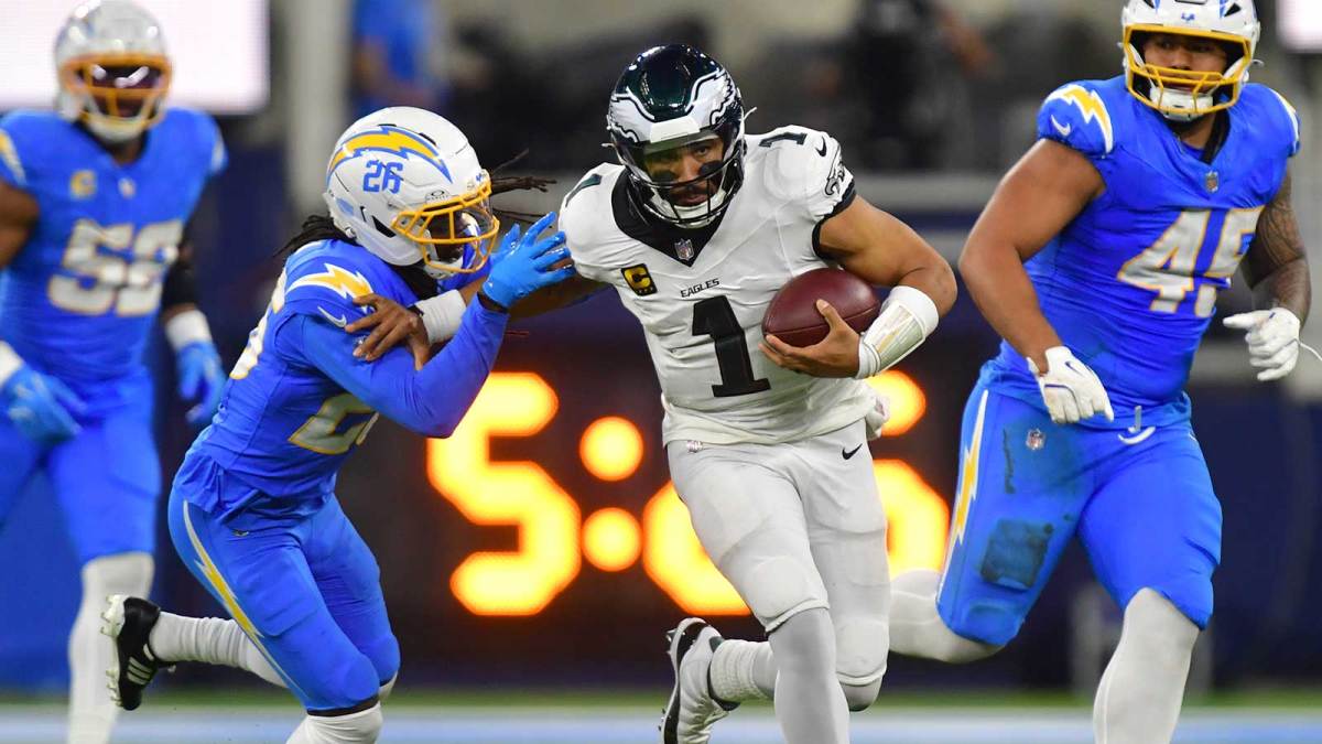 Philadelphia Eagles quarterback Jalen Hurts (1) runs against Los Angeles Chargers cornerback Donte Jackson (26) in overtime at SoFi Stadium.