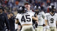 Wake Forest Demon Deacons head coach Jake Dickert (center) chest bumps Demon Deacons defensive back Nick Andersen (45) after the Demon Deacons blocked a touchdown pass in the final seconds of the second half against the Virginia Cavaliers at Scott Stadium.
