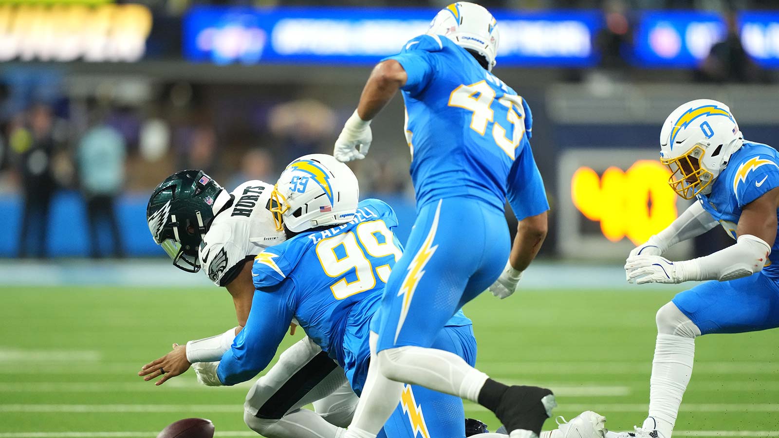 Los Angeles Chargers defensive tackle Jamaree Caldwell (99) tackles Philadelphia Eagles quarterback Jalen Hurts (1) in the first half at SoFi Stadium.