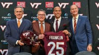 John Rocovich, Timothy Sands, James Franklin and Whit Babcock hold up a Virginia Tech jersey during the press conference celebrating Franklin as head coach at Cassell Coliseum.