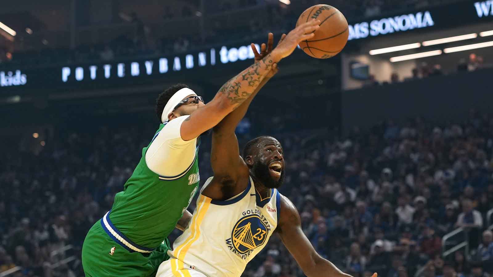 Golden State Warriors forward Draymond Green (23) rebounds against Dallas Mavericks forward Anthony Davis (center left) during the first quarter at Chase Center.