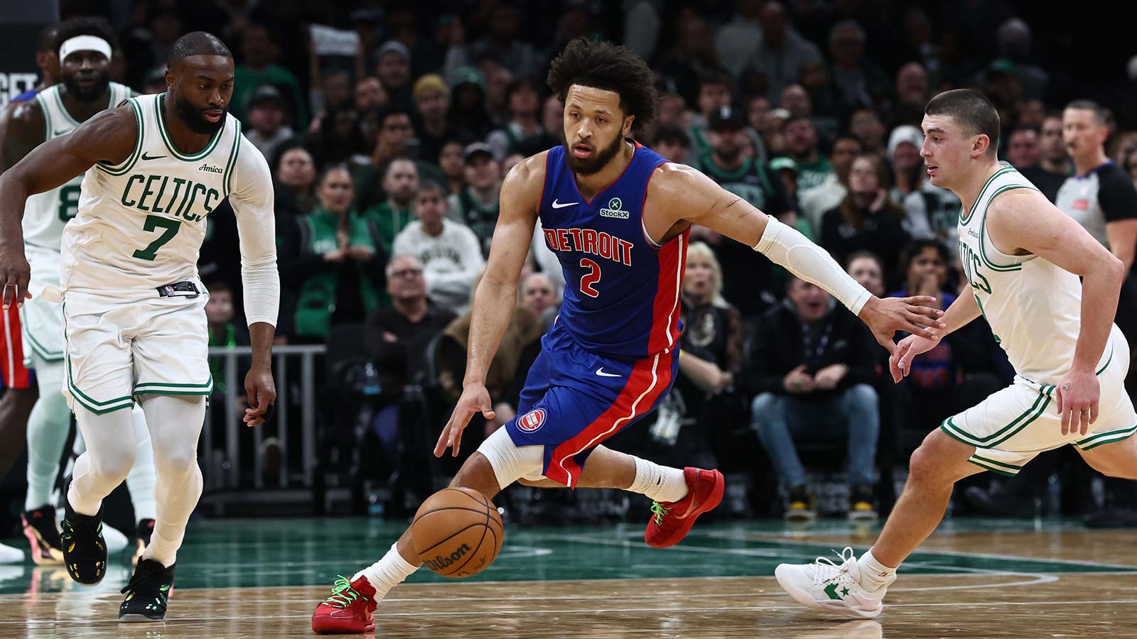 Detroit Pistons guard Cade Cunningham (2) dribbles between Boston Celtics guard Jaylen Brown (7) and guard Payton Pritchard (11) during the second half at TD Garden.