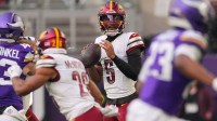 Washington Commanders quarterback Jayden Daniels (5) drops back to pass against the Minnesota Vikings during the first half at U.S. Bank Stadium.