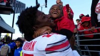 Ohio State Buckeyes tight end Jelani Thurman (15) hugs his little brother, Jream Jackson, as he leaves the field following the 24-6 win over the Washington Huskies in the NCAA football game at Husky Stadium in Seattle