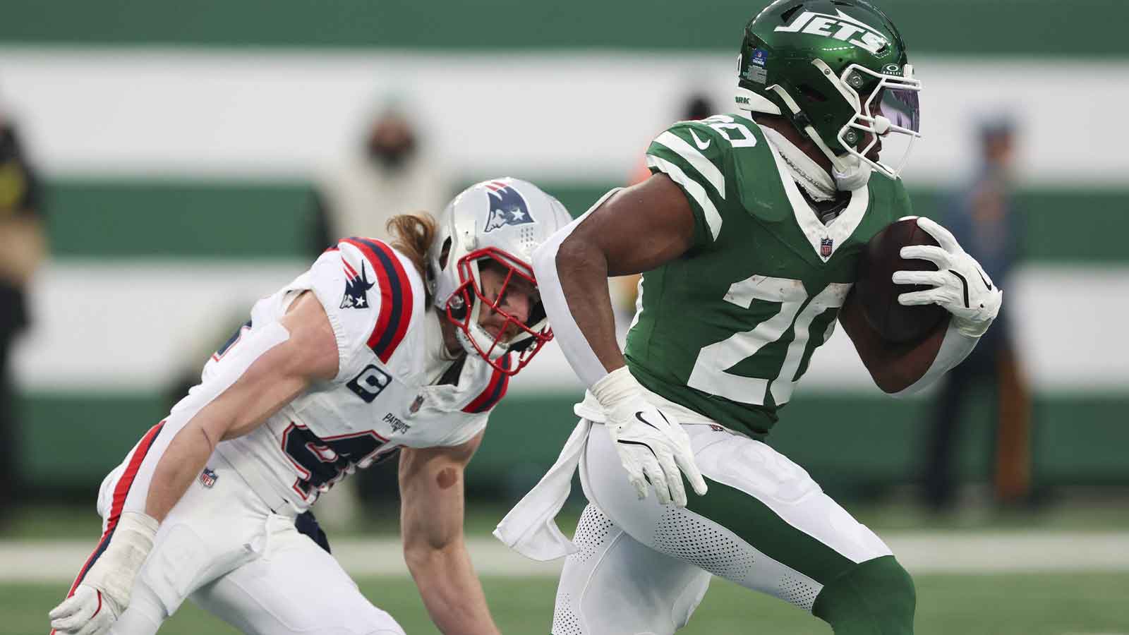  New York Jets running back Breece Hall (20) runs for a touchdown against New England Patriots safety Brenden Schooler (41) during the second half of the game at MetLife Stadium