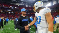 Los Angeles Chargers head coach Jim Harbaugh talks to quarterback Justin Herbert (10) after a victory over the Atlanta Falcons at Mercedes-Benz Stadium.