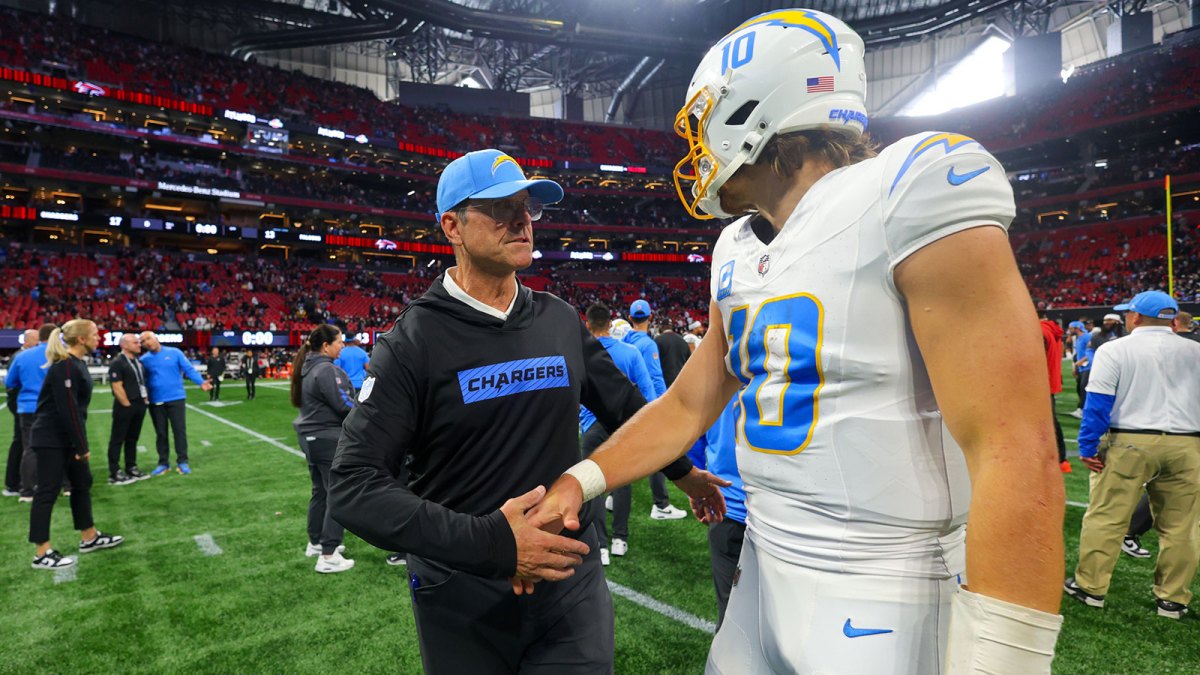 Los Angeles Chargers head coach Jim Harbaugh talks to quarterback Justin Herbert (10) after a victory over the Atlanta Falcons at Mercedes-Benz Stadium.