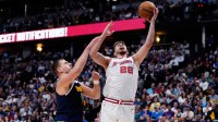 Houston Rockets center Alperen Sengun (28) shoots the ball past Denver Nuggets center Nikola Jokic (15) in the second quarter at Ball Arena.