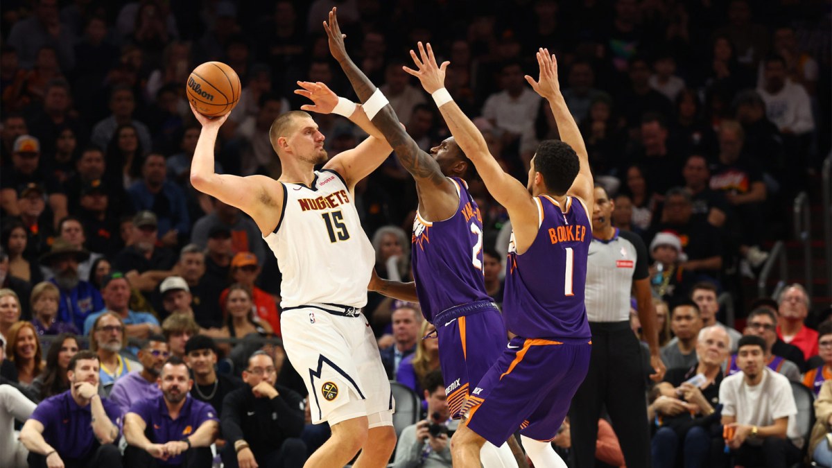 Denver Nuggets center Nikola Jokic (15) controls the ball against Phoenix Suns forward Nigel Hayes-Davis (21) and guard Devin Booker (1) in the first half at the Mortgage Matchup Center.
