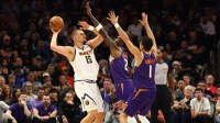 Denver Nuggets center Nikola Jokic (15) controls the ball against Phoenix Suns forward Nigel Hayes-Davis (21) and guard Devin Booker (1) in the first half at the Mortgage Matchup Center.
