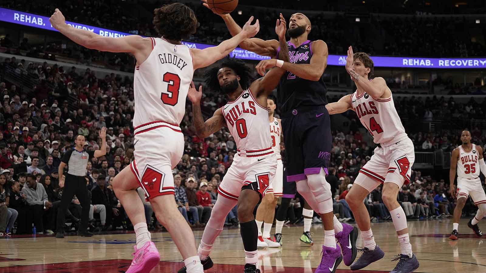 Chicago Bulls guard Josh Giddey (3) guard Coby White (0) defends Minnesota Timberwolves center Rudy Gobert (27) at United Center.
