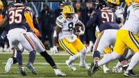 Green Bay Packers running back Josh Jacobs (8) runs the ball against Chicago Bears defensive tackle Andrew Billings (97) and safety C.J. Gardner-Johnson (35) during the first quarter at Soldier Field.