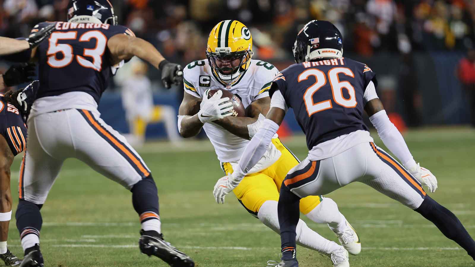 Green Bay Packers running back Josh Jacobs (8) runs the ball against Chicago Bears linebacker T.J. Edwards (53) and cornerback Nahshon Wright (26) during the first quarter at Soldier Field. 