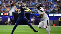 ; Los Angeles Chargers quarterback Justin Herbert (10) throws the ball as Houston Texans defensive tackle Sheldon Rankins (90) applies the pressure during the first half at SoFi Stadium.