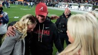 Alabama head coach Kalen DeBoer celebrates with his wife and daughters after Alabama defeated Auburn at Jordan-Hare Stadium.
