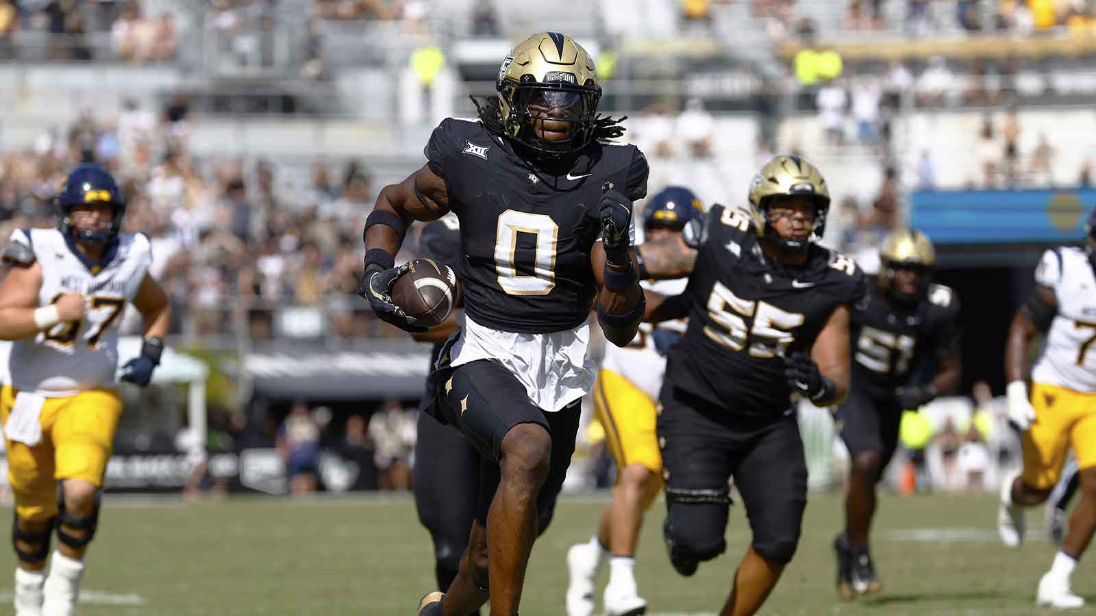 Central Florida Knights linebacker Keli Lawson (0) scoops a fumble and returns it for a second half touchdown against the West Virginia Mountaineers at Acrisure Bounce House.