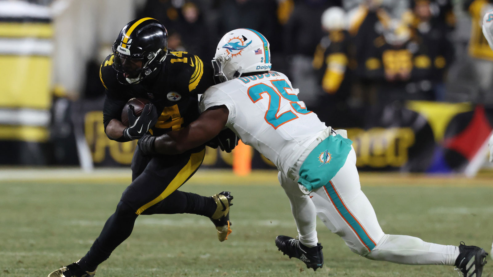 Pittsburgh Steelers running back Kenneth Gainwell (14) is tackled by Miami Dolphins linebacker Tyrel Dodson (25) in the third quarter at Acrisure Stadium. 