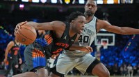 Knicks forward Og Anunoby (8) dribbles the ball past San Antonio Spurs forward Harrison Barnes (40) in the second half during the Emirates NBA Cup Final at T-Mobile Arena with a Knicks reporter in the background