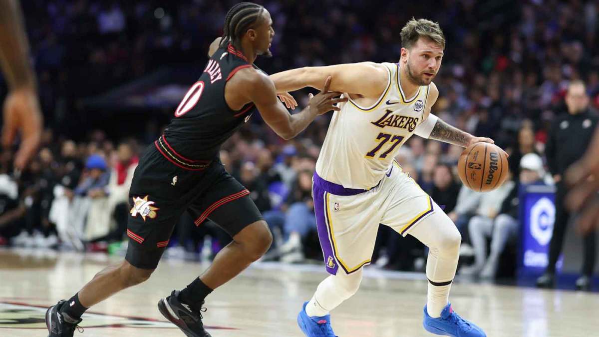 Los Angeles Lakers guard Luka Doncic (77) dribbles past Philadelphia 76ers guard Tyrese Maxey during the second quarter at Xfinity Mobile Arena.
