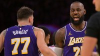 Lakers guard Luka Doncic (77) and forward LeBron James (23) react after a foul during the first half against the Los Angeles Clippers at Crypto.com Arena