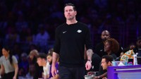 Lakers head coach JJ Redick watches game action against the Houston Rockets during the first half at Crypto.com Arena with the Pistons logo in the background