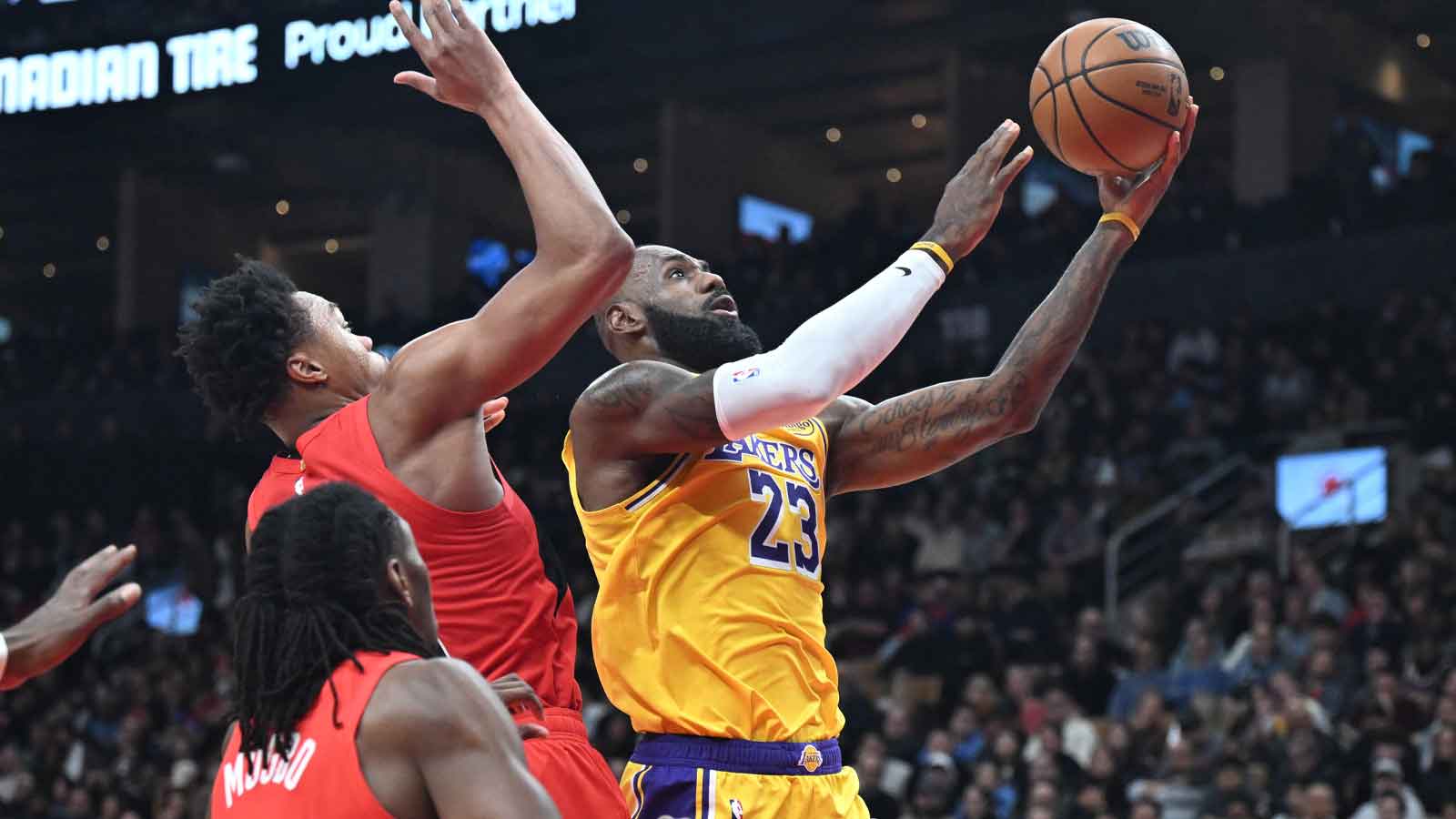 Los Angeles Lakers forward LeBron James (23) shoots the ball as Toronto Raptors forward Scottie Barnes (4) defends in the first half at Scotiabank Arena.