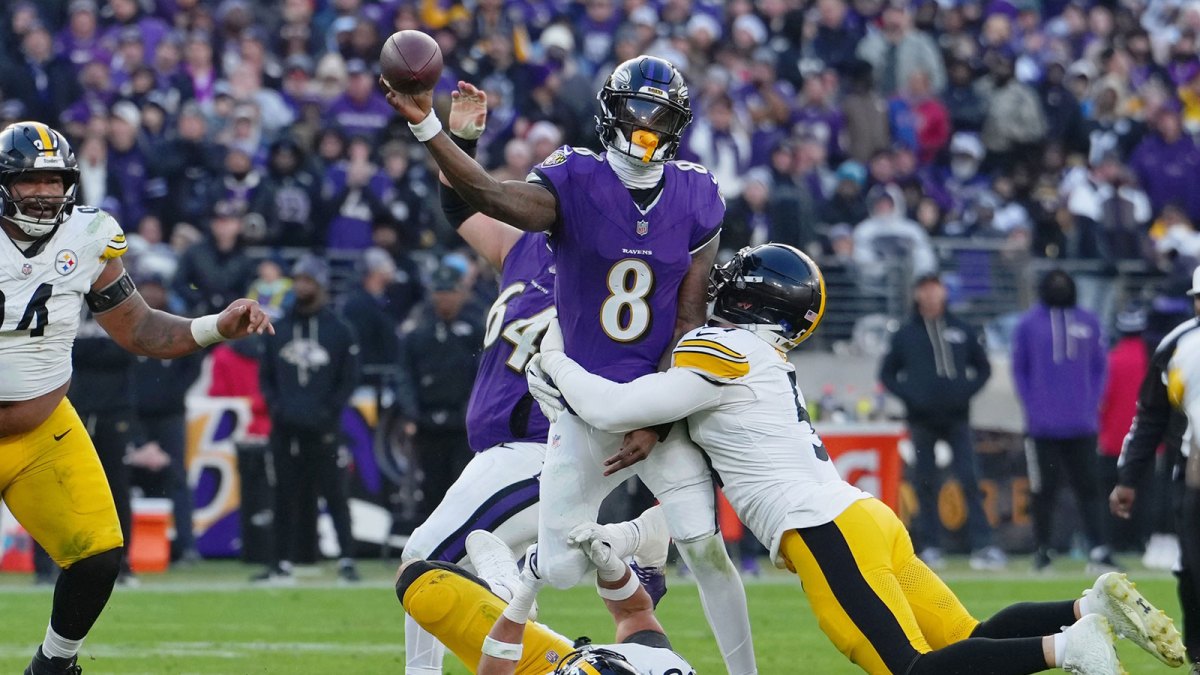 Baltimore Ravens quarterback Lamar Jackson (8) passes the ball while defended by Pittsburgh Steelers linebacker Alex Highsmith (56) and linebacker Nick Herbig (51) during the second half at M&T Bank Stadium.