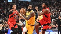 Los Angeles Lakers forward LeBron James (23) drives to the basket between Toronto Raptors guard Immanuel Quickley (5) and forward Collin Murray-Boyles (12) in the first half at Scotiabank Arena.
