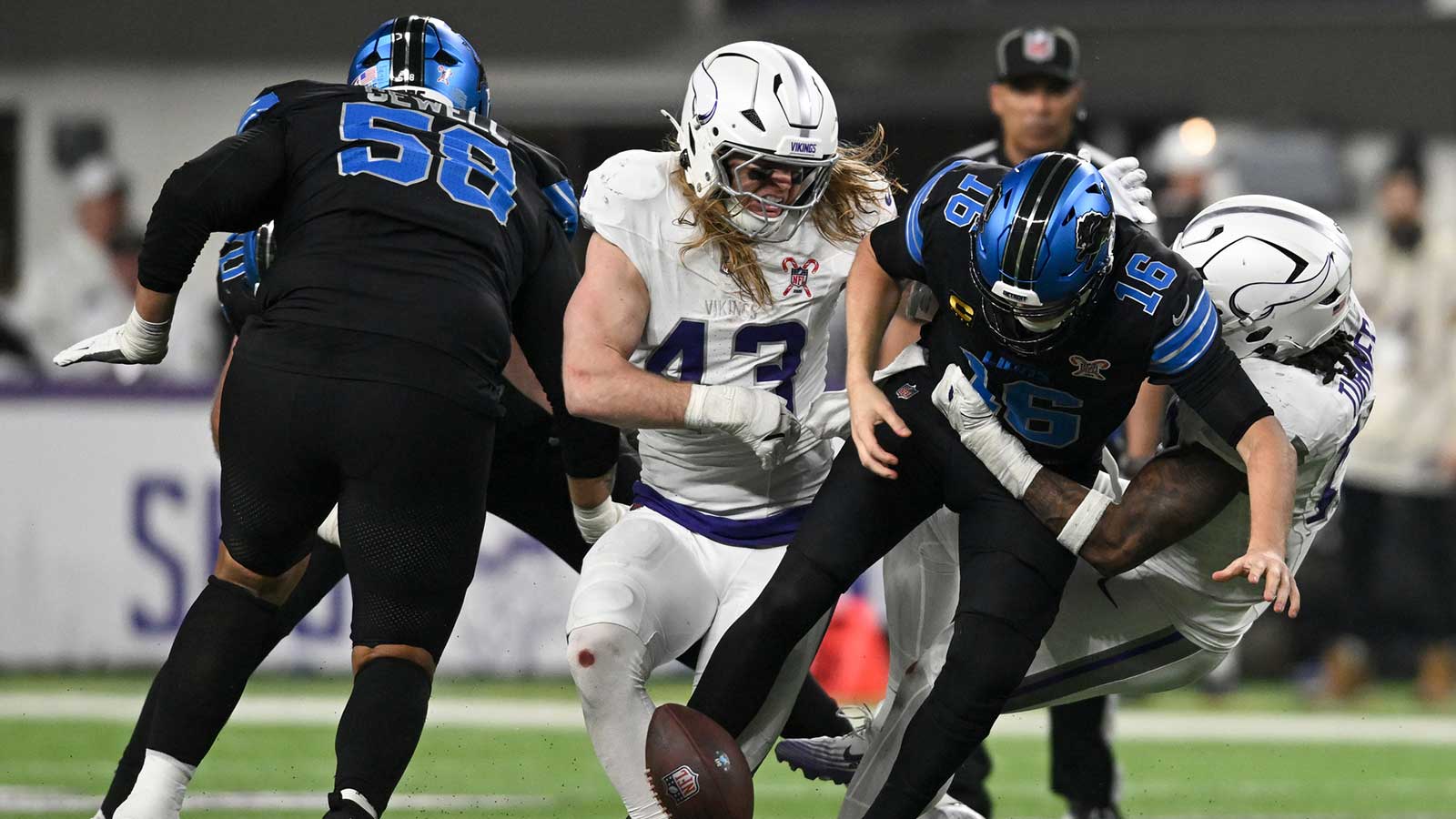 Detroit Lions quarterback Jared Goff (16) fumbles the ball defended by Minnesota Vikings linebacker Andrew van Ginkel (43) and linebacker Dallas Turner (15) in the fourth quarter at U.S. Bank Stadium.