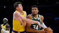 Los Angeles Lakers guard Austin Reaves (15) defends Milwaukee Bucks forward Giannis Antetokounmpo (34) as he drives to the basket in the first half at Crypto.com Arena.