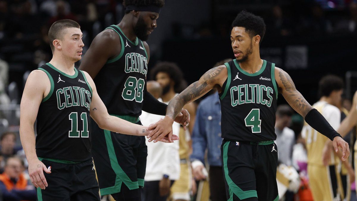 Boston Celtics guard Payton Pritchard (11) celebrates with Celtics center Neemias Queta (88) and Celtics guard Anfernee Simons (4) against the Washington Wizards in the second half at Capital One Arena.