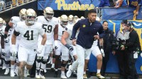 Notre Dame Fighting Irish head coach Marcus Freeman (right) leads the team onto the field to play the Pittsburgh Panthers at Acrisure Stadium.