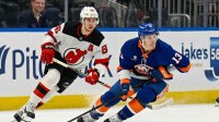 New York Islanders center Mathew Barzal (13) skates with the puck defended by New Jersey Devils center Jack Hughes (86) during the first period at UBS Arena