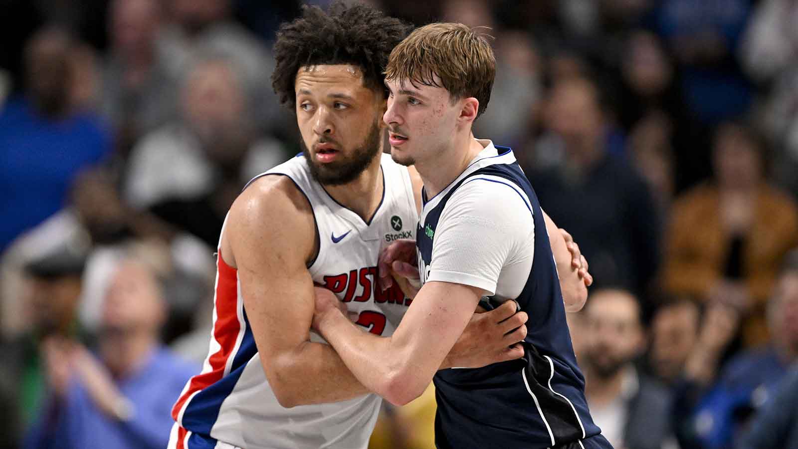 Pistons guard Cade Cunningham (2) and Dallas Mavericks forward Cooper Flagg (32) look for the ball during overtime at the American Airlines Center