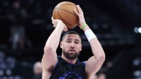 Mavericks guard Klay Thompson (31) warms up before the game against the Utah Jazz at Delta Center with the 76ers logo in the background