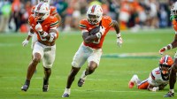 Miami Hurricanes defensive back Keionte Scott (0) returns an interception for a touchdown in a game against the Syracuse Orange during the second quarter at Hard Rock Stadium.