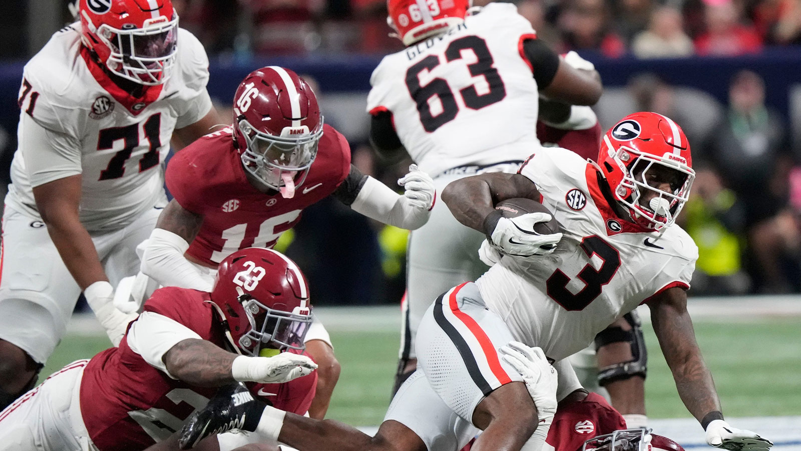 Alabama defensive lineman James Smith (23) and Alabama defensive lineman Jordan Renaud (11) combine to bring down Georgia running back Nate Frazier (3) at Mercedes-Benz Stadium.
