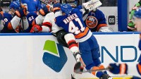 New York Islanders defenseman Marshall Warren (41) checks New Jersey Devils right wing Stefan Noesen (11) into the boards during the third period at UBS Arena.