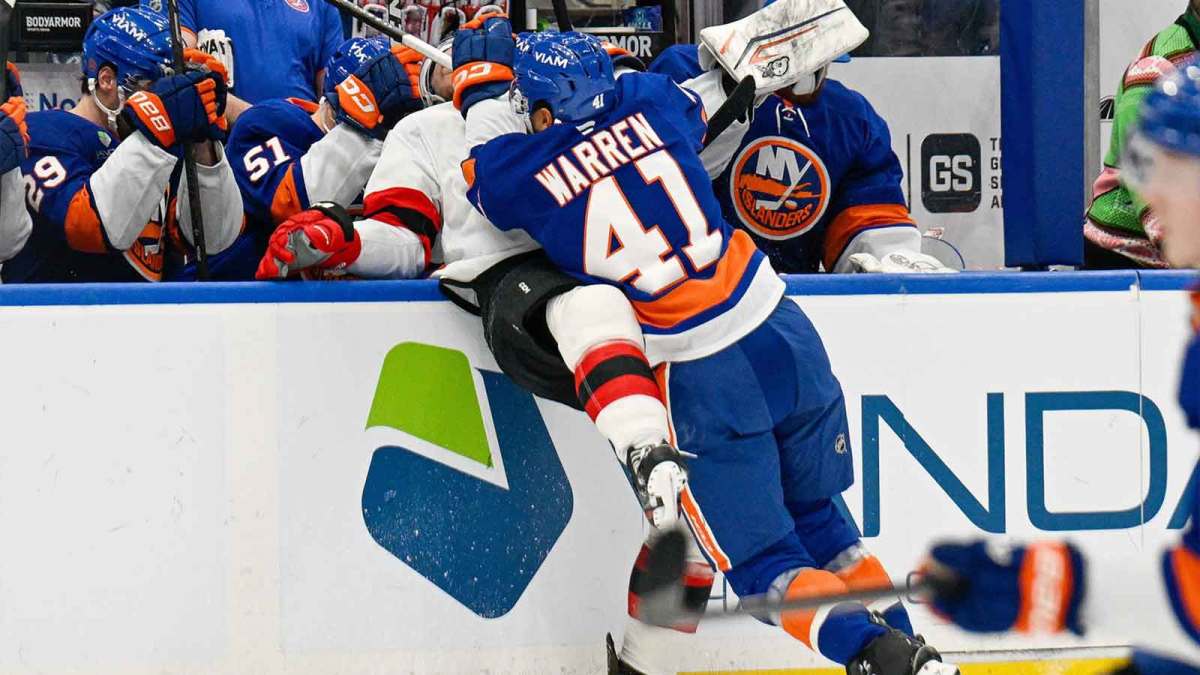 New York Islanders defenseman Marshall Warren (41) checks New Jersey Devils right wing Stefan Noesen (11) into the boards during the third period at UBS Arena.