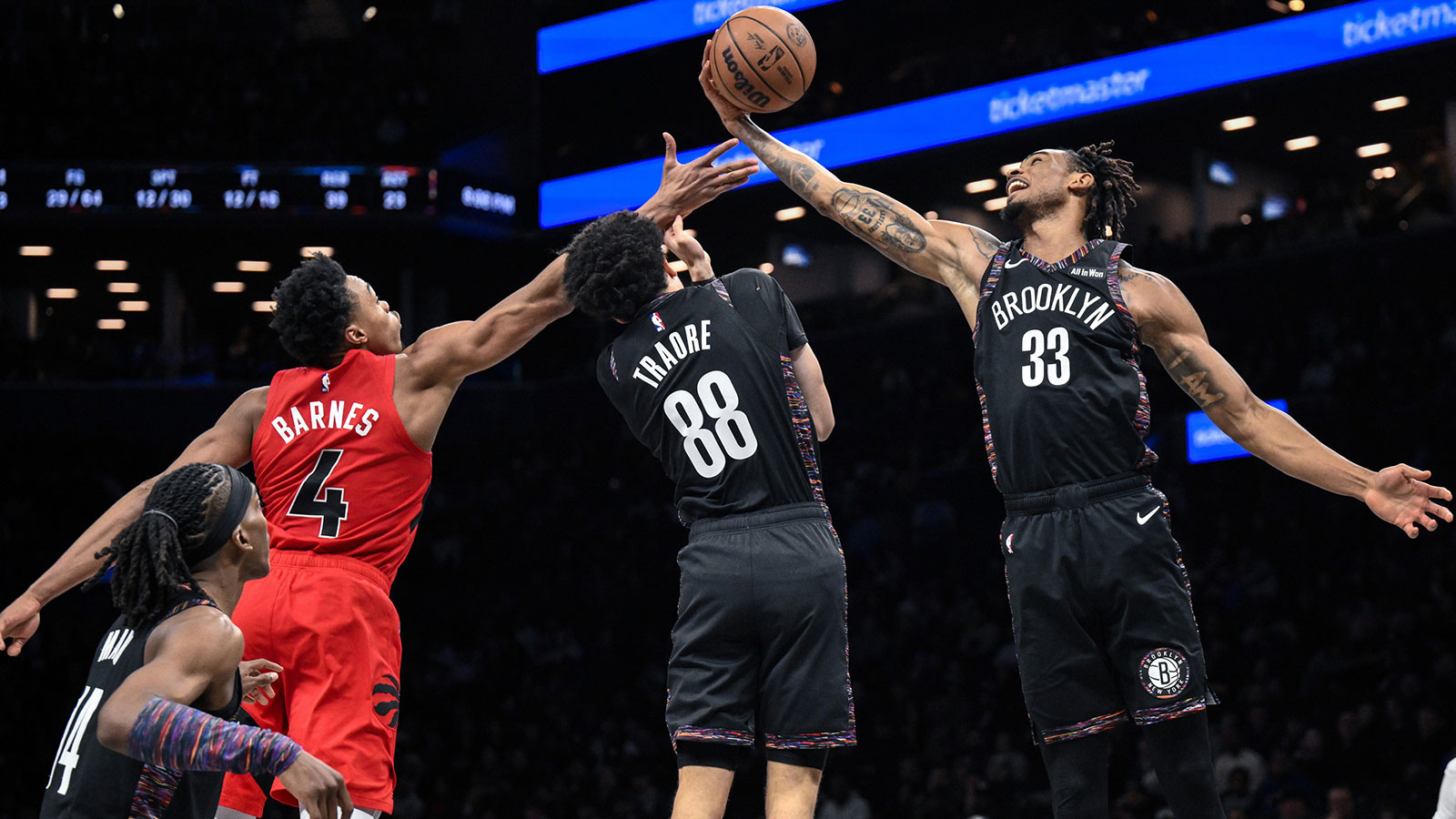 Brooklyn Nets center Nic Claxton (33) grabs a rebound against Toronto Raptors forward/guard Scottie Barnes (4) during the second half at Barclays Center.