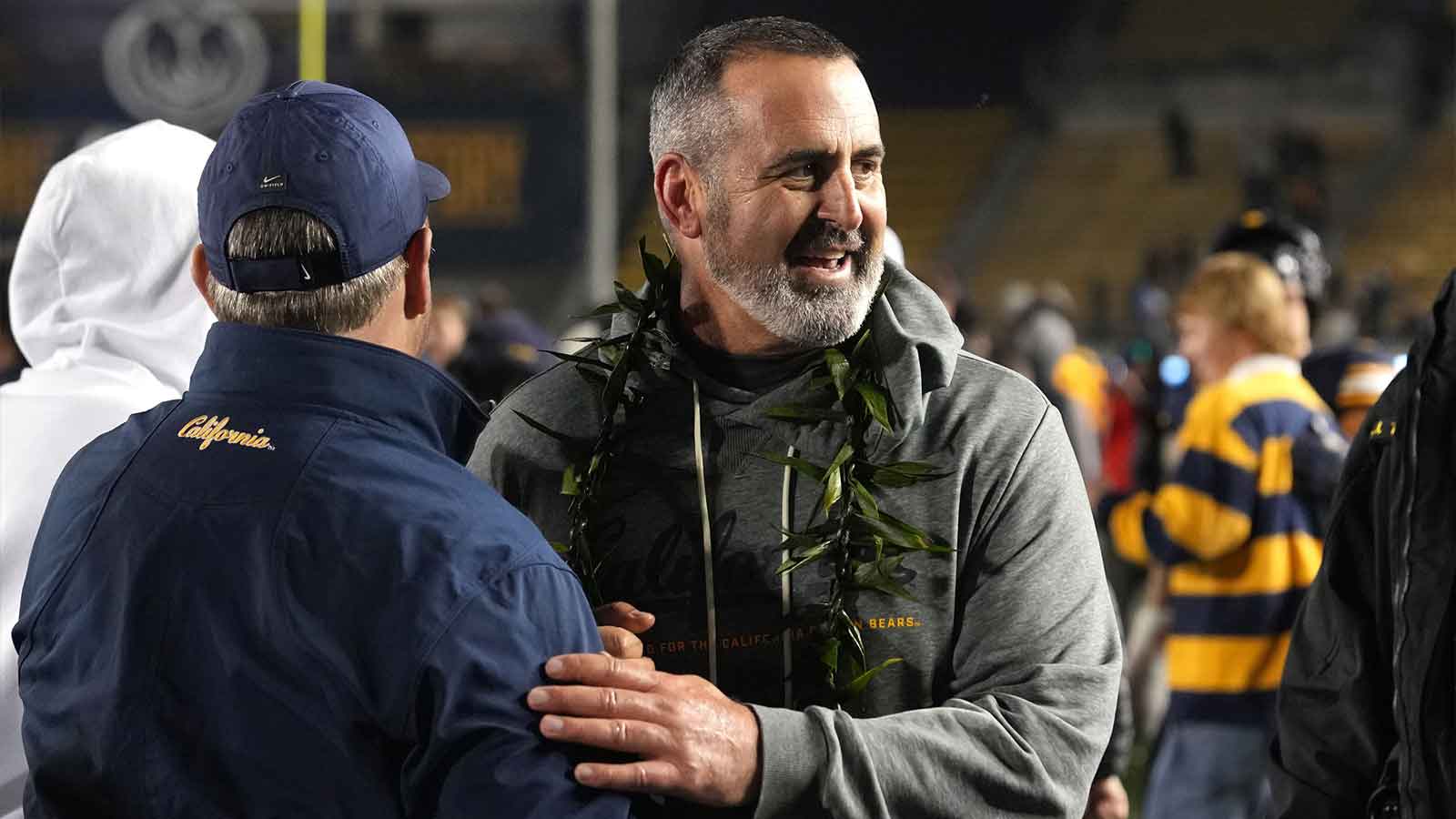California Golden Bears interim head coach Nick Rolovich (center) celebrates with a fan on the field after defeating the Southern Methodist Mustangs at California Memorial Stadium.